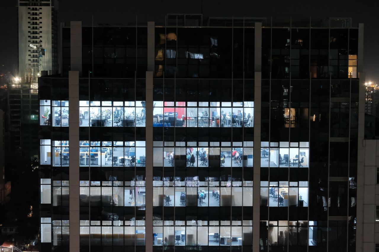 A night view of an office building in Central Visayas, Philippines, showcasing illuminated office windows.